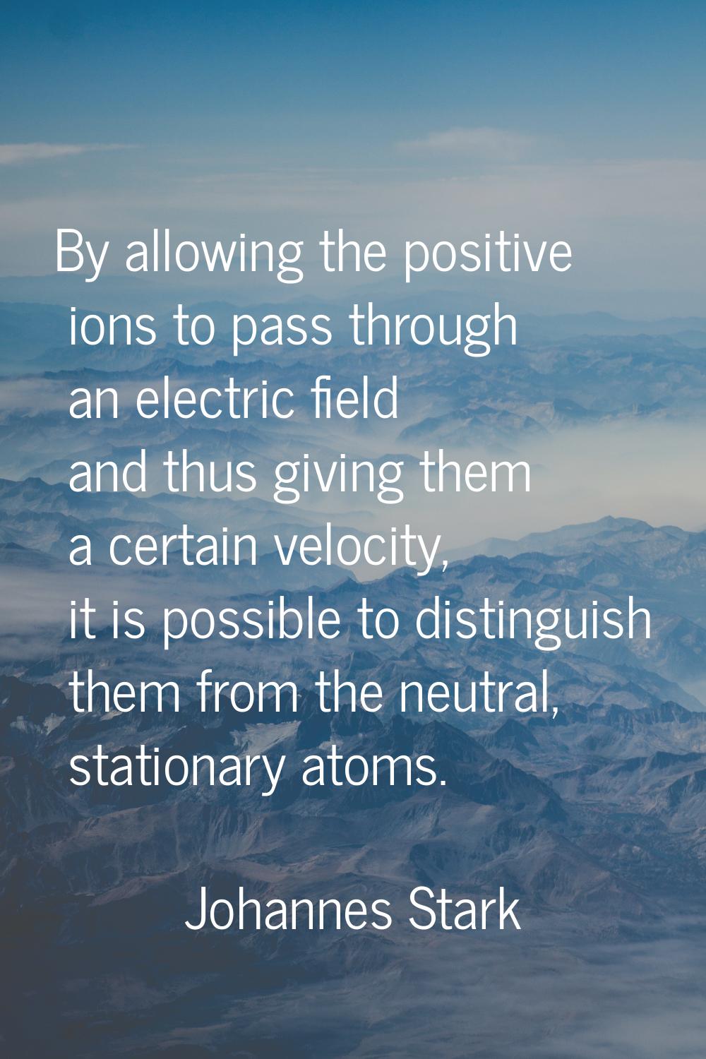 By allowing the positive ions to pass through an electric field and thus giving them a certain velo